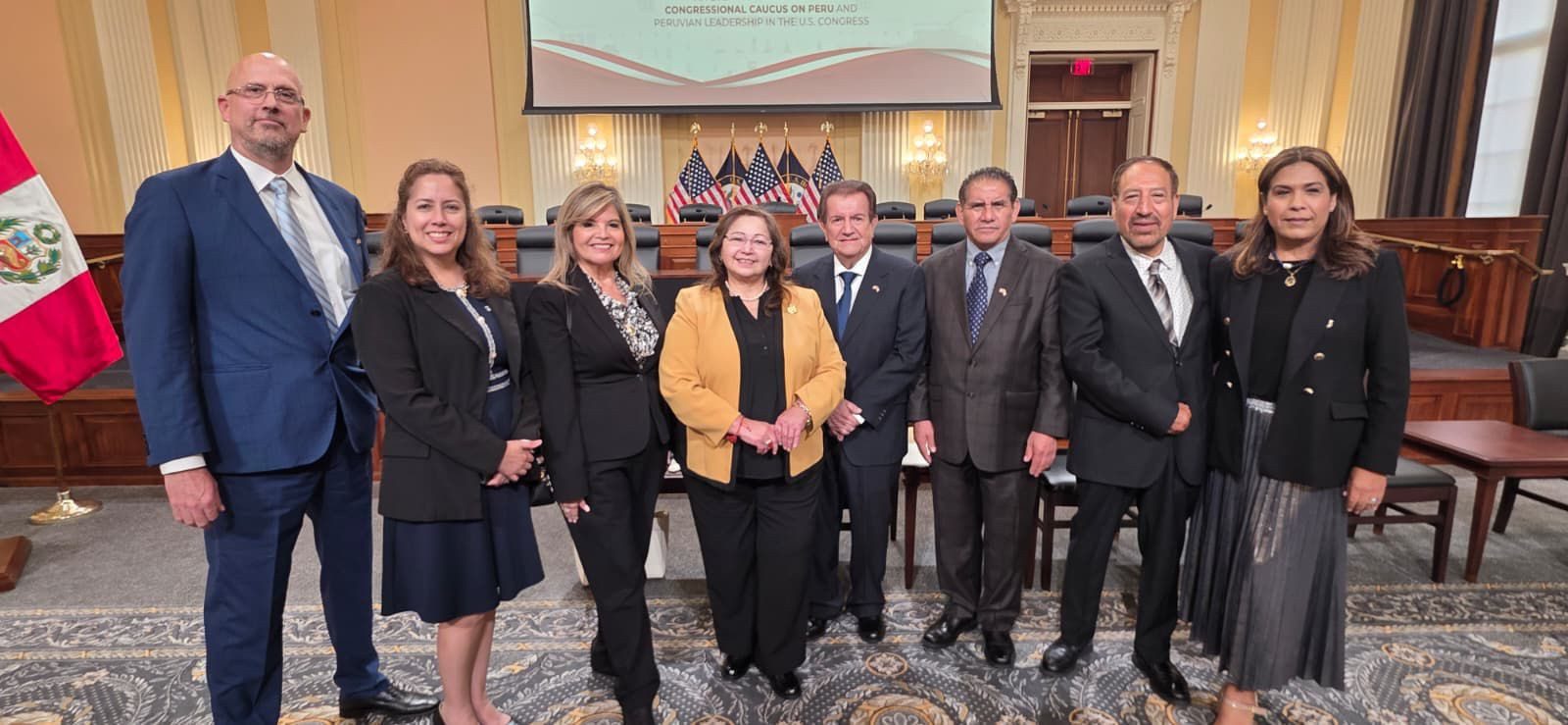 Delegación de PAPO-USA en la Cámara de Representantes con la bandera de Perú al fondo