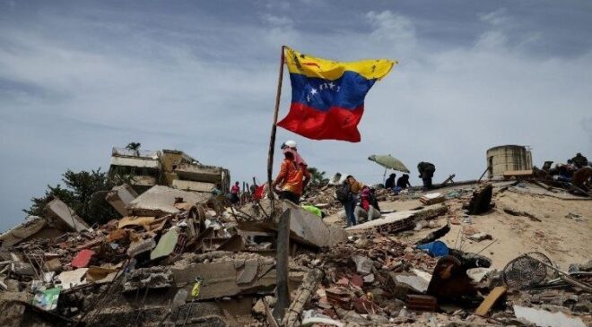 Escombros y bandera de Venezuela tras el terremoto en La Guaira